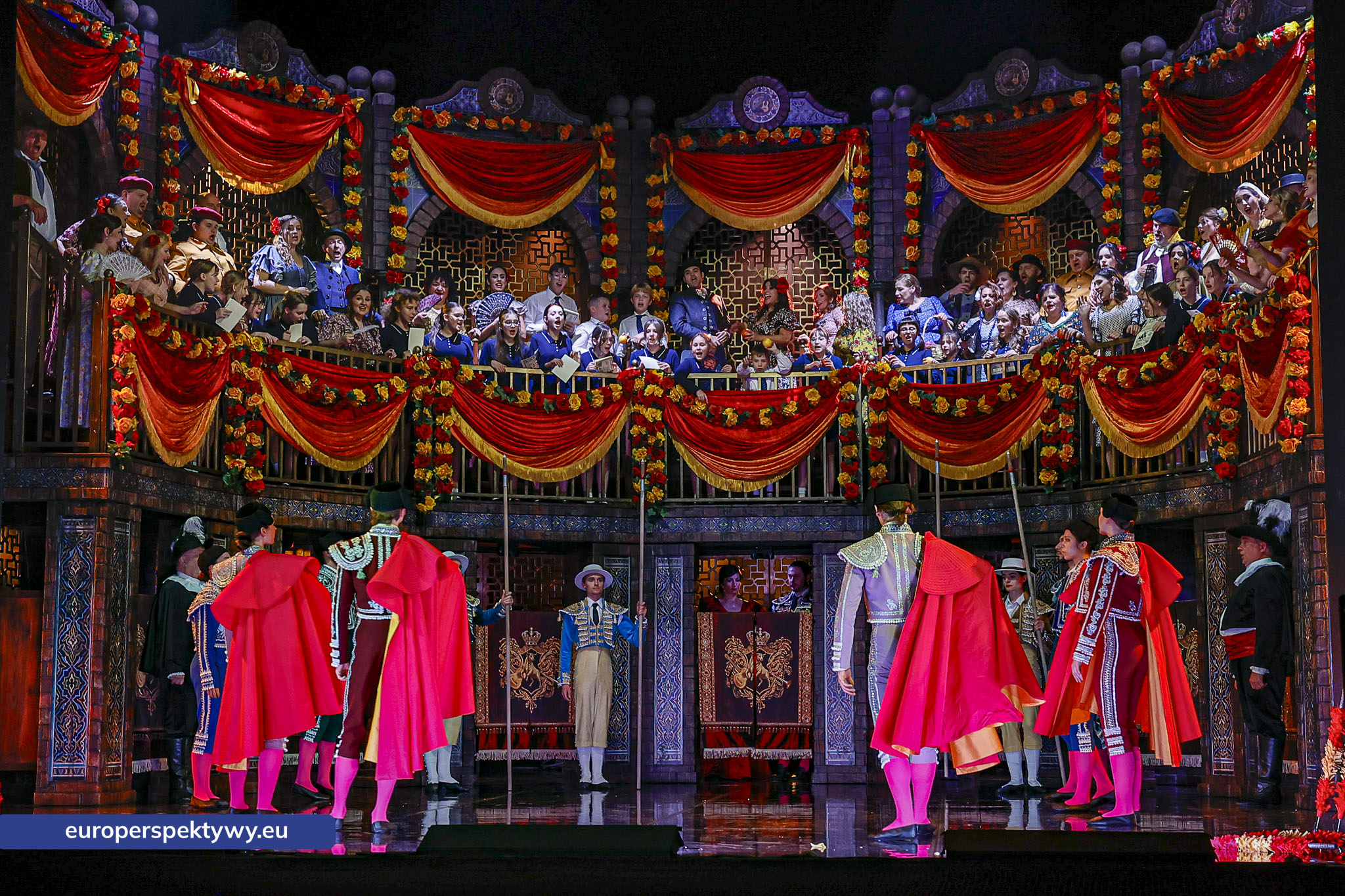 Czerwone peleryny przed areną Orszak w czerwonych pelerynach przed areną, opera Carmen w Operze Śląskiej w Bytomiu