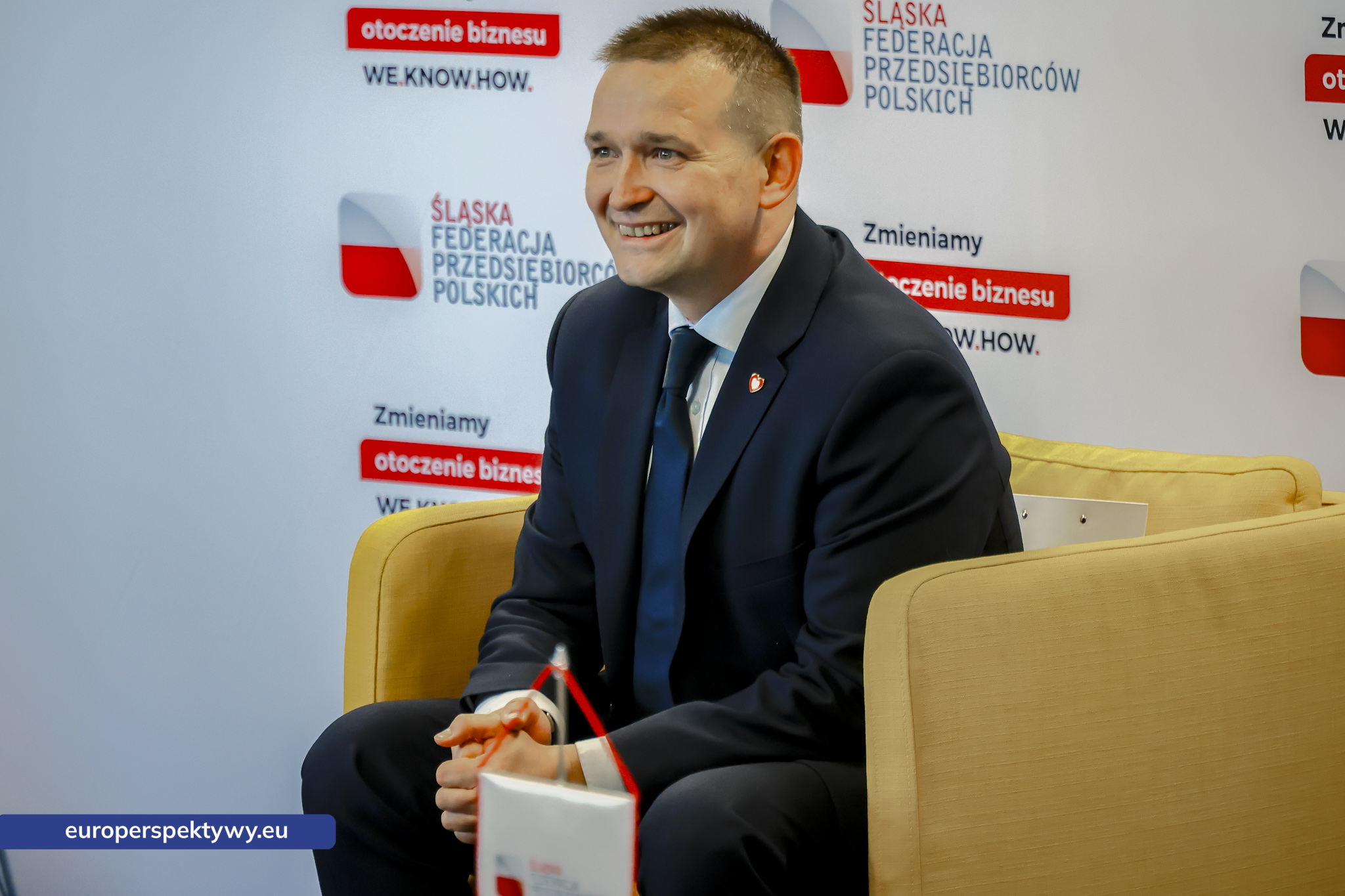 Michał Jaros, wiceminister rozwoju i technologii, na tle ścianki Śląskiej Federacji Przedsiębiorców Polskich